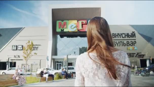 Vrolijk vrouw in wit luie blouse loopt naar winkelcentrum — Stockvideo