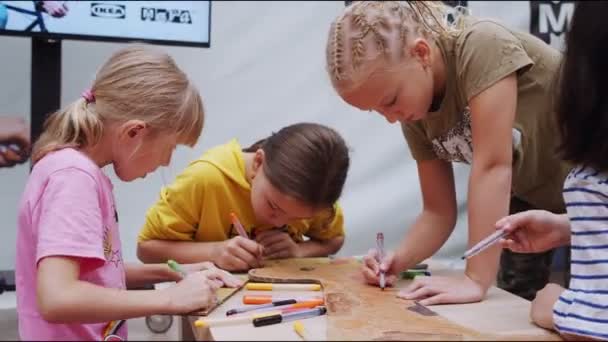 Meisjes verf karton giraffe met heldere kleuren aan tafel — Stockvideo