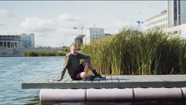 Homem simula beber e jogar garrafa no rio — Vídeo de Stock