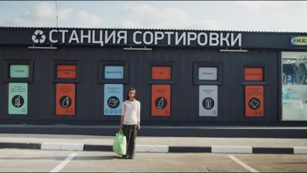 Nő tart nagy táska áll közel szemét válogató állomás — Stock videók