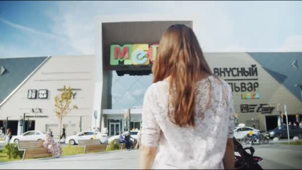 Jonge dame in wit luie blouse loopt naar Mega winkelcentrum — Stockvideo