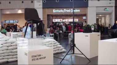 Geri dönüşüm malzemelerinden yapılmış ürün örnekleriyle birlikte duruyor