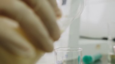 asistan masadaki kaliteyi kontrol etmek için şişeye süt döker