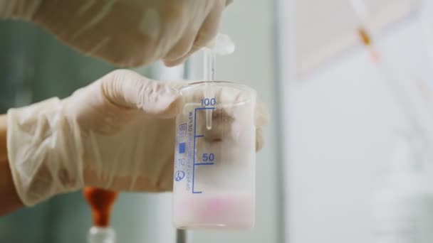 Laboratoriumassistent voegt reagens toe aan melkonderzoek in laboratorium — Stockvideo