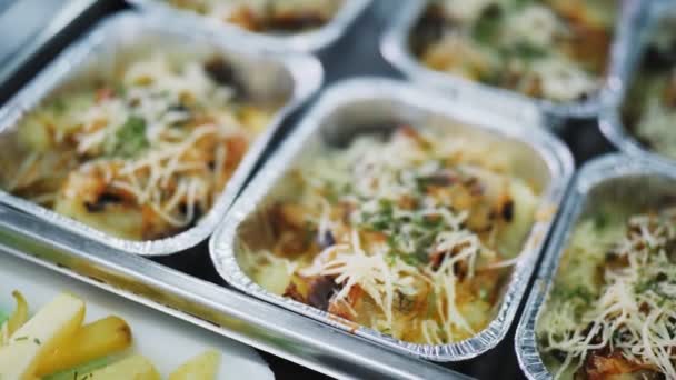 Folie containers van heerlijke maaltijd op kantine teller closeup — Stockvideo