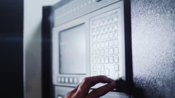 Werknemer drukt op knoppen op het bedieningspaneel in de werkplaats — Stockvideo