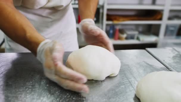 Пекарь делает хлеб буханку теста на металлическом столе замедленной съемки — стоковое видео