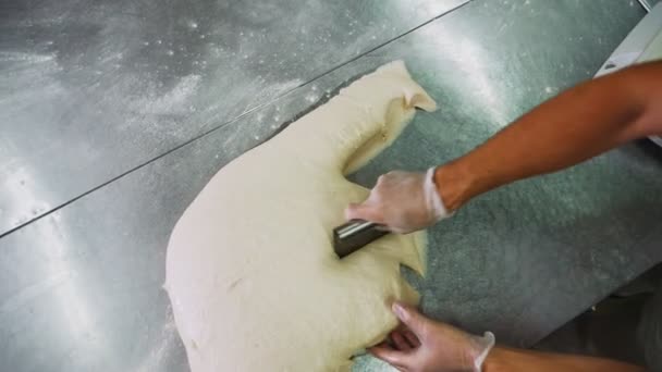 Bakker gesneden deeg op metalen tafel in workshop slow motion — Stockvideo