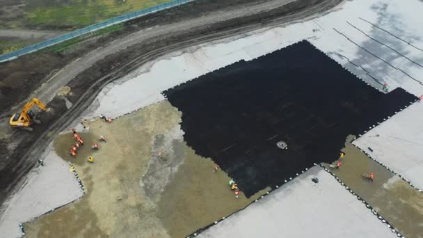 Constructores ponen arena en la rejilla negra en el sitio de construcción — Vídeo de stock