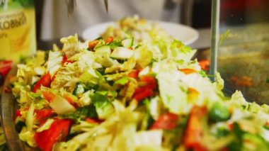 İşçi lezzetli salatayı Çin lahanasıyla karıştırır.