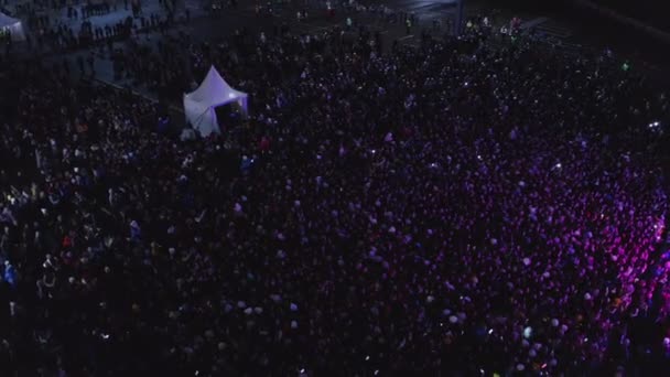 Gran multitud de fanáticos de la música disfruta del espectáculo en el escenario por la noche — Vídeos de Stock