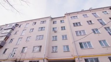 Kişi kış günü apartmanın bahçesinde yürür.
