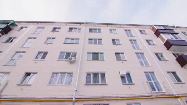 Zaśnieżony dziedziniec odnowionego apartamentowca pod szarym niebem — Wideo stockowe