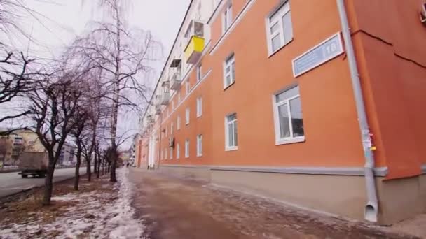 Façade orange du bâtiment d'habitation dans la rue le jour de l'hiver — Video