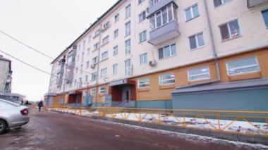 dwelling building with bright facade on street in winter