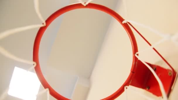 Camera turns fast under red basketball hoop with white net — ストック動画