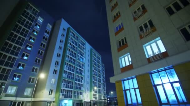 Kompleks budynków blokowych przy ulicy miejskiej w zimową noc — Wideo stockowe