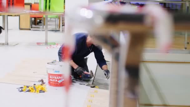 Worker puts concrete mix onto floor in entertainment center — Stock Video