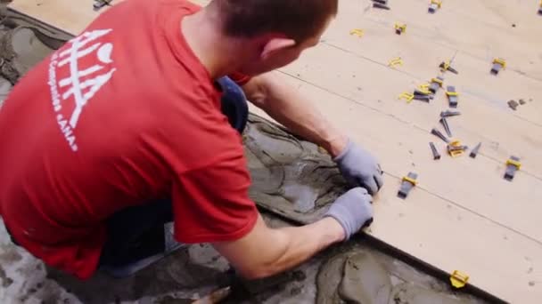 Робітник кладе суміш на підлогу, щоб розкласти плитки в торговому центрі. — стокове відео