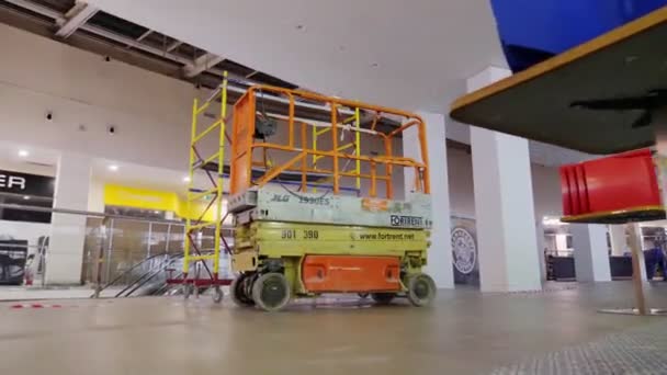 Moderne schaarlift en steiger in de bouw in winkelcentrum — Stockvideo