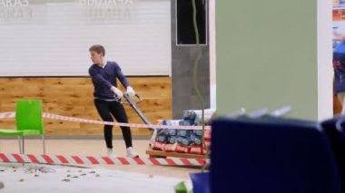 İnşaat işçisi ve iş arkadaşı, inşaat alanında çantalarla birlikte palet çekiyorlar.