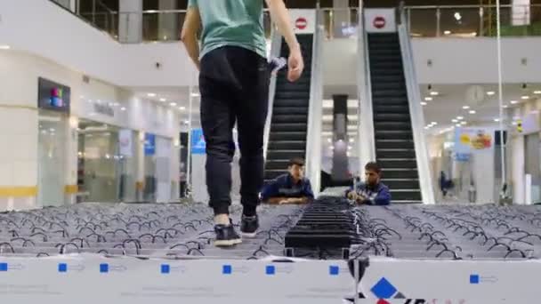 Electrician walks along illuminating construction in mall — Stock Video