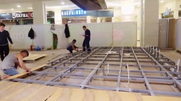 Les constructeurs mettent des planches en bois sur le sol avec des carcasses métalliques — Video