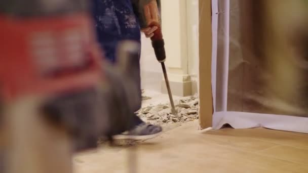 Worker with jackhammer destroys concrete covering on floor — Stockvideo