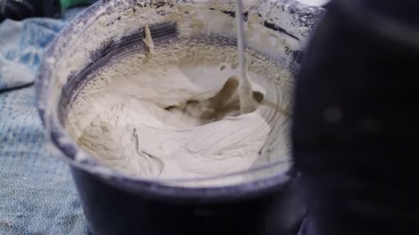 Skilled worker prepares mixture in bucket at construction — 图库视频影像