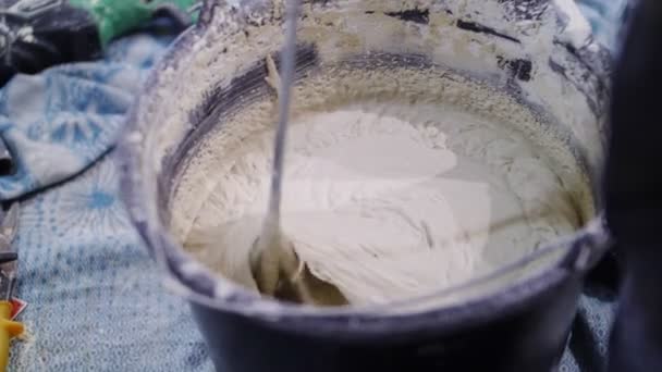 Worker prepares mix in bucket with modern instrument closeup — 비디오