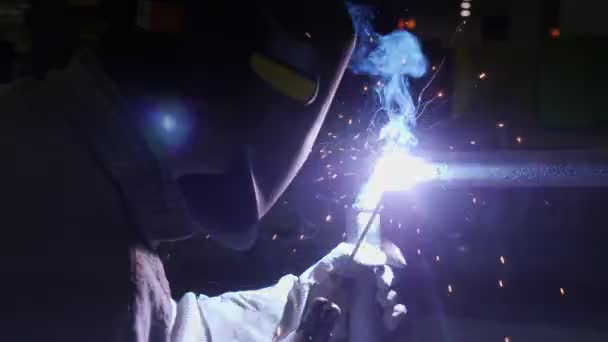 Laborer in protective mask welds pipe at construction — Stockvideo