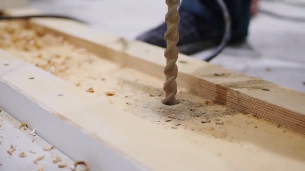 Boorgat in houten plaat met werktuig op de vloer — Stockvideo