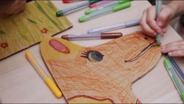 Дети рисуют картон яркими красками на столе крупным планом — стоковое видео