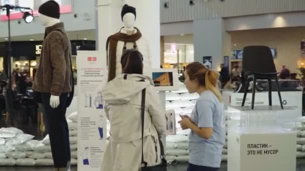 Vrijwilligerswerk praat met gast door informatiestand op tentoonstelling — Stockvideo