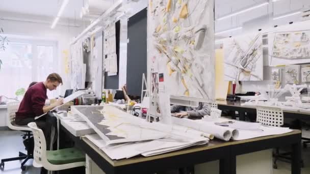 Jovens arquitetos discutir novo projeto em escritório espaçoso — Vídeo de Stock