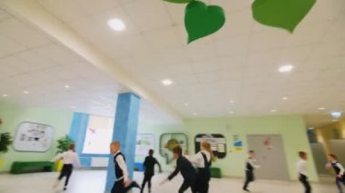 Mutlu okul çocukları teneffüste salonda kovalamaca oynarlar.
