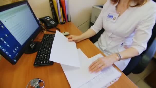 Médico maduro trabalha com registros no local de trabalho no escritório — Vídeo de Stock