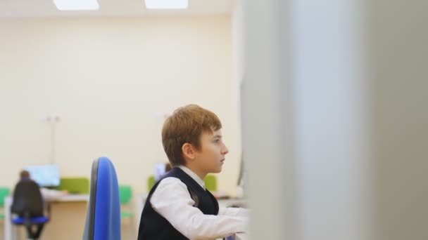 Preteen αγόρι εργάζεται στον υπολογιστή στην τάξη του νέου σχολείου — Αρχείο Βίντεο