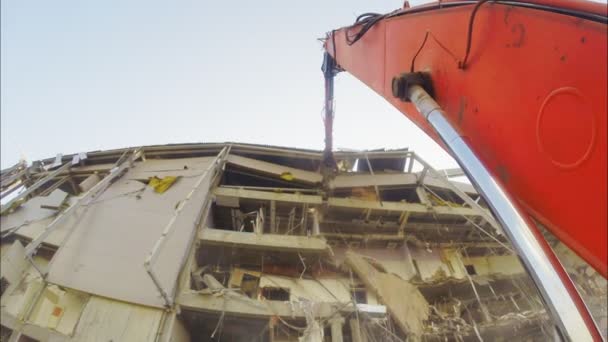 Máquina roja con brazo largo rompe viejo edificio de arena deportiva — Vídeos de Stock