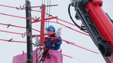 Elektrikçi, eski direğe elektrik hatları kurmayı kontrol ediyor