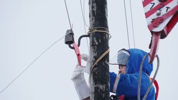 Robotnik naprawia przerwany przewód przesyłowy energii elektrycznej po biegunie — Wideo stockowe