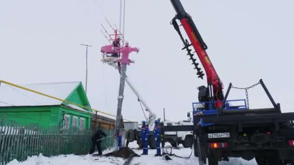 Nákladní jeřáb zvedá betonovou tyč pro napájecí vedení ve vesnici — Stock video