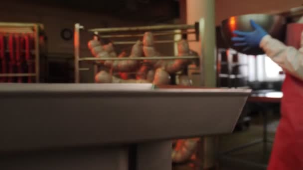 Работник в форме наливает сырое мясо говядины в металлический контейнер — стоковое видео