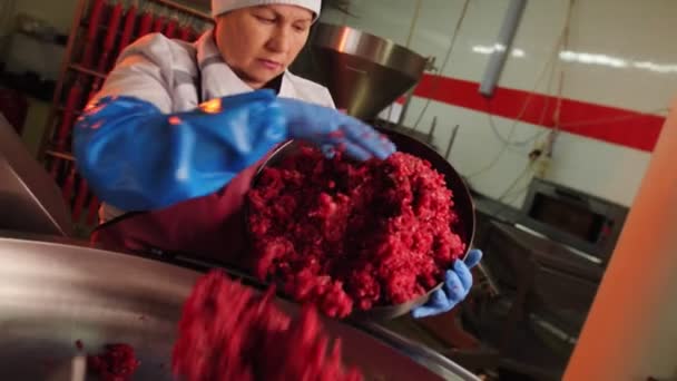 Trabajadora madura pone carne picada en primer plano depósito — Vídeo de stock