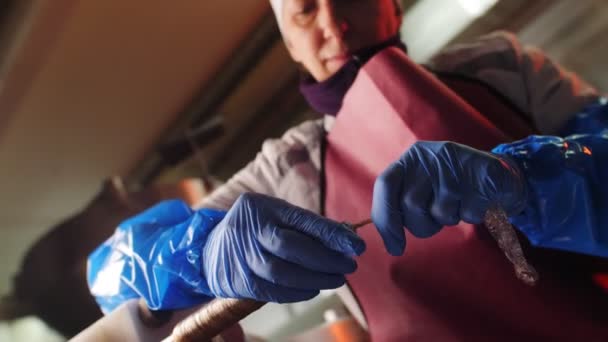 Lavoratore in guanti riempie involucro salsiccia con carne in officina — Video Stock