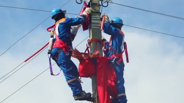 Arbeiter mit Gurten reparieren kaputte Hochspannungsleitung — Stockvideo