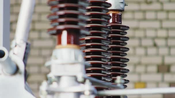 Line of shiny ceramic insulators at electrical substation — Stock Video