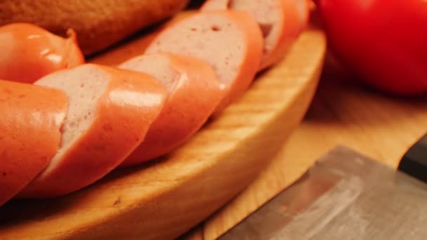 Rodajas de sabrosas salchichas cerca de pan de centeno en la mesa de madera — Vídeos de Stock