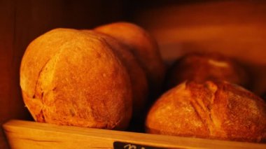 Modern pastanenin ahşap rafında taze ekmek somunları
