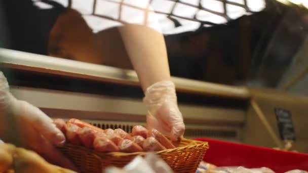 Vendedora coloca salsichas saborosas em vitrine na mercearia — Vídeo de Stock